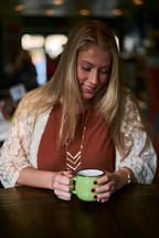 a woman drinking coffee in a sweater 