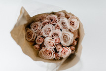 bouquet of pink roses in brown paper 