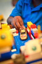 boy child playing with legos and a toy car