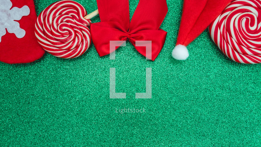 Flatlay of some red Christmas decoration, on a green background. Background for Christmas.