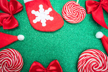 Flatlay of some red Christmas decoration, on a green background. Background for Christmas.