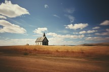 Vintage photo of small church in the field. Retro style.