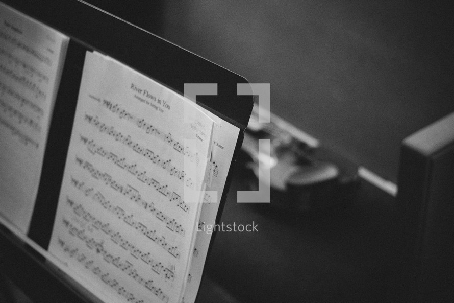 sheet music on a music stand and violin 