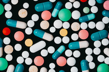 Pharmacy theme. Multicolored Isolated Pills and Capsules on Black Surface. Vitamins, drugs concept. COVID-19, Coronavirus, epidemic. High quality photo
