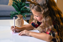 child addressing a gift tag to mom 