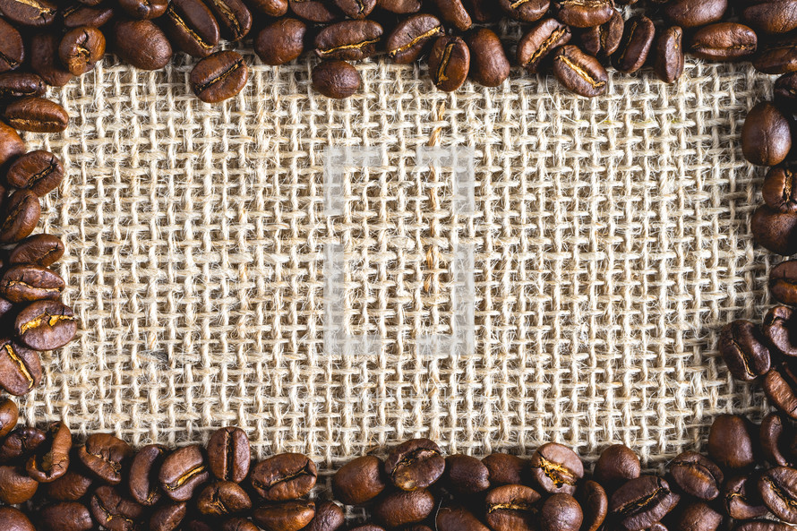 A frame of Coffee beans, on Burlap fabric. Background voor coffee related products.
