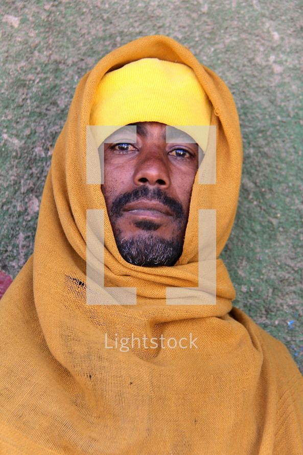 Ethiopian Orthodox Eunuch man wearing a yellow robe [For similar search Ethnic Face Smile]