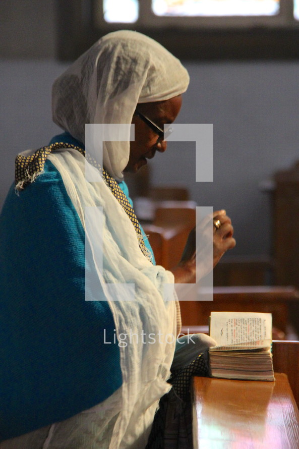 An elderly Ethiopian Orthodox woman in prayer 