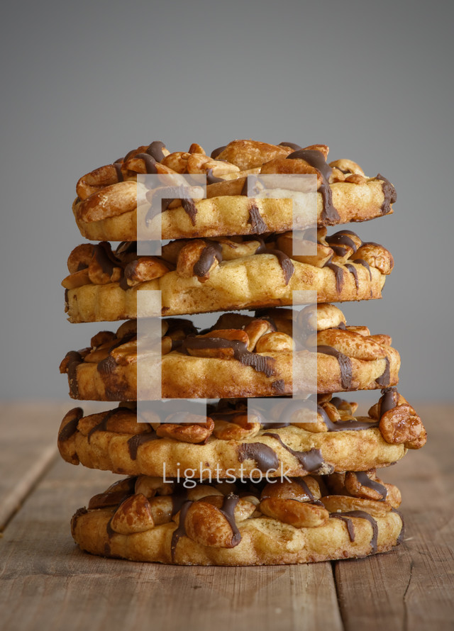 A stack of cookies on a wooden surface.