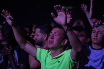 men with raised hands in an audience 