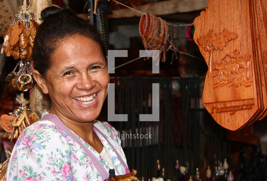 A woman vendor at a booth in a street market 