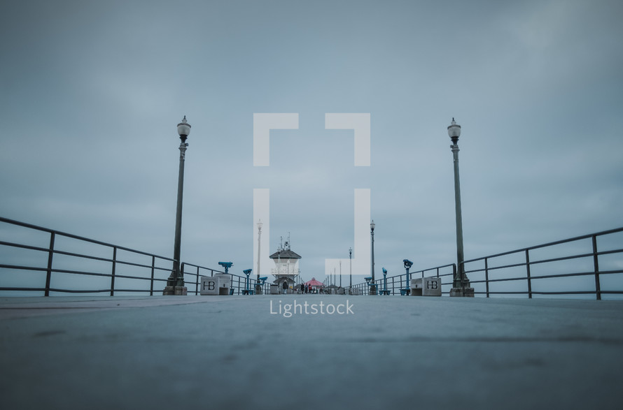 Lamps on a pier on a cloudy day | Huntington Beach | California | Low Shot | Perspective | Background | Depth | People | Lights | Early Morning | Outside | Outdoors 