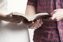 Couple holding an open Bible.