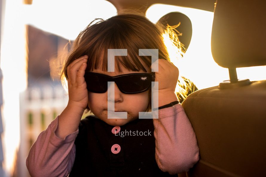 girl wearing sunglasses in a car 