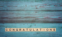 Congratulations in scrabble pieces on a teal background 