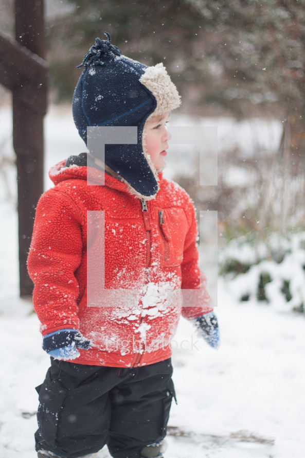 a boy child playing in the snow 