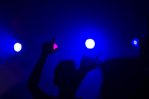 audience with raised hands at a concert 