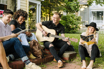 man playing a guitar outdoors at a Bible study 