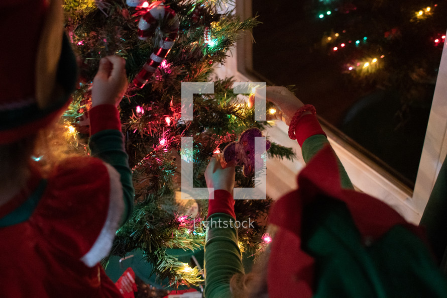 kids decorating a Christmas tree