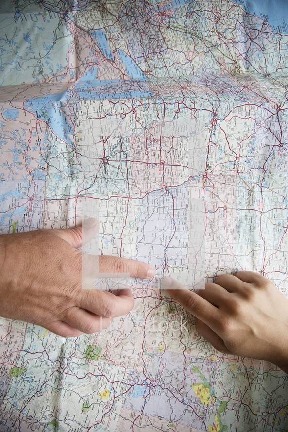 two fingers pointing to a location on a map. 