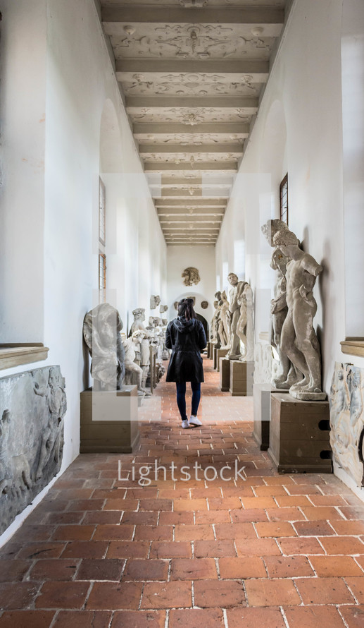a woman admiring statues in a museum 