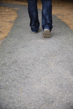 man walking down a paved path.