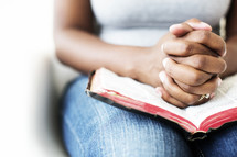 African-American woman reading a Bible in her lap 