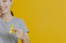 holding a yellow ribbon 