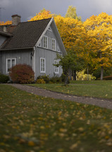 Rustic Swedish barn amidst colorful trees in autumn