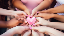 Hands of women holding pink heart for breast cancer day concept