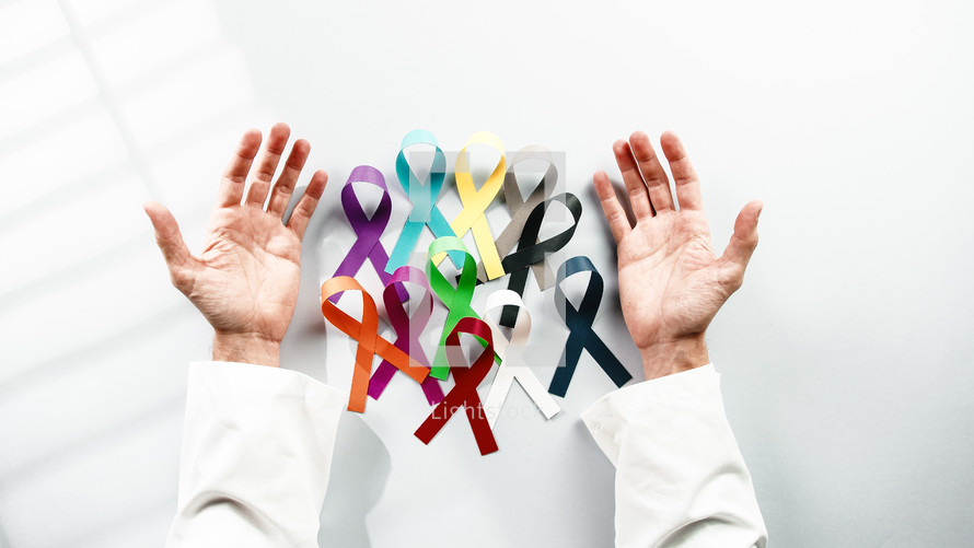 world cancer awareness day and ribbons in the hand of a doctor