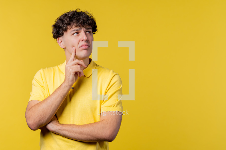 Thinking around man on yellow background. Smart student guy finding answer or trying to remember what he forgot, memory concept. High quality