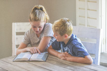 a brother and sister reading a Bible 