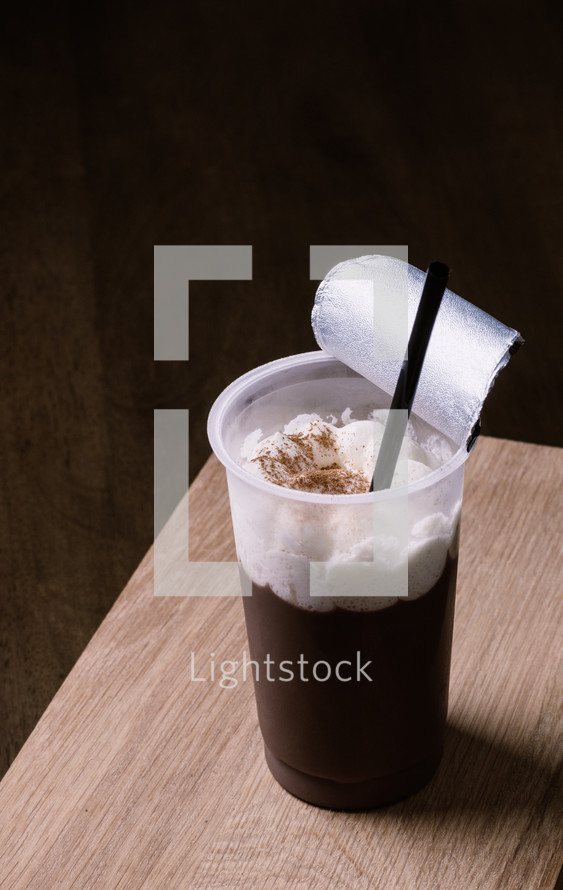 chocolate pudding with straw on wooden table