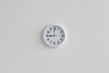 A white wall clock on a white wall.