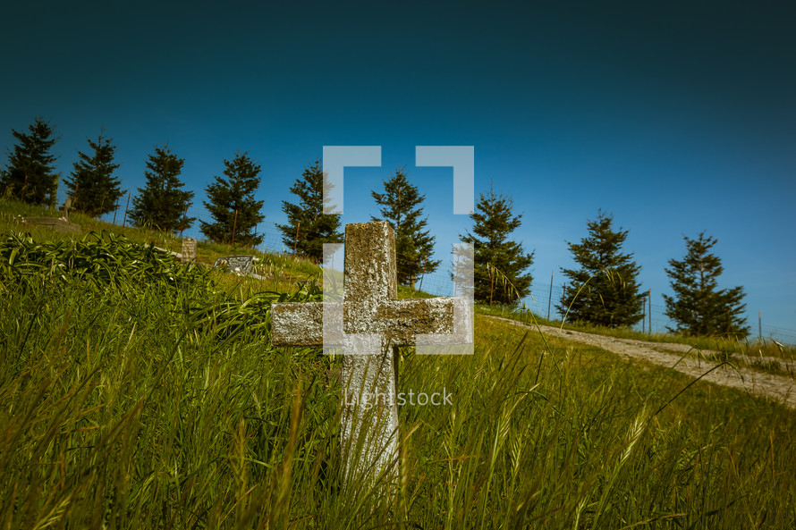 cross on a grassy hill 