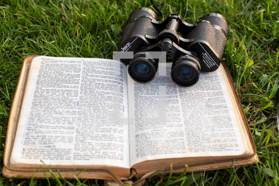 open Bible with binoculars 