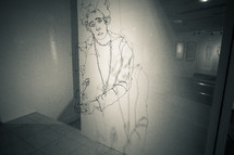 Line drawing of a woman projected on a wall.