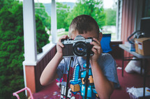 a boy child taking a picture with a camera 