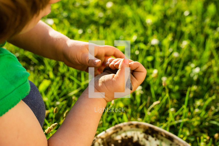 toddler girl playing with an earthworm 