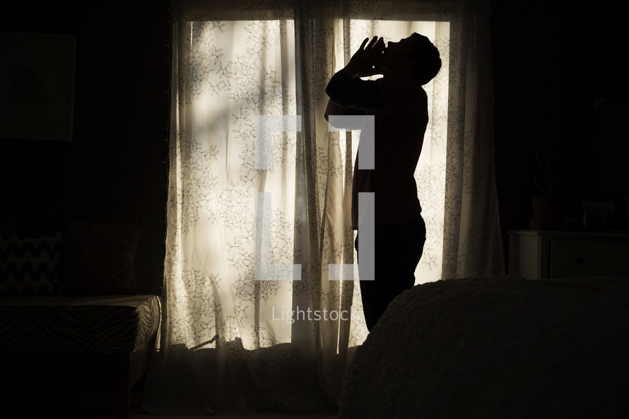 silhouette of a man frustrated in his bedroom.