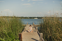 girl praying on a pier 