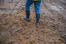 rain boots walking through mud on a farm 