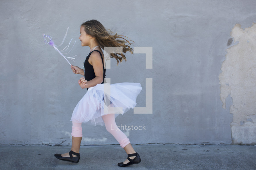 a little girl playing dress up 