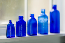 row of blue glass bottles 