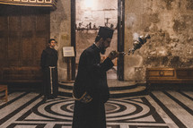 a man with incense in Church of the Holy Sepulchre