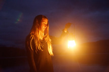 a woman holding a glowing lantern 