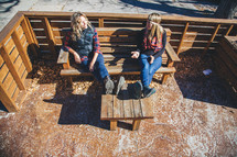 women sitting on a bench in a patio talking outdoors 