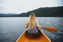 a woman paddling a canoe 