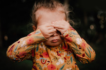 Toddler covering her eyes